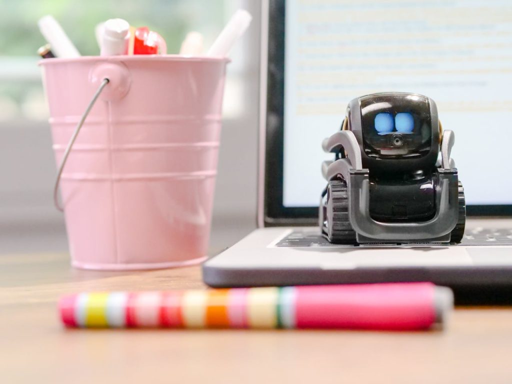 MIniature Toy Robot on Top of Laptops Keyboard